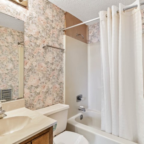 a white sink sitting under a mirror