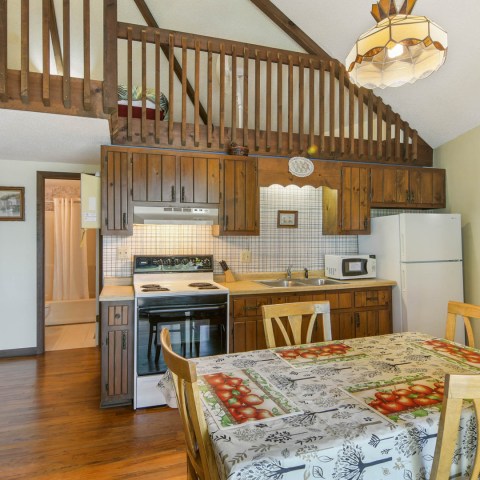 a kitchen with wooden cabinets and a dining room table