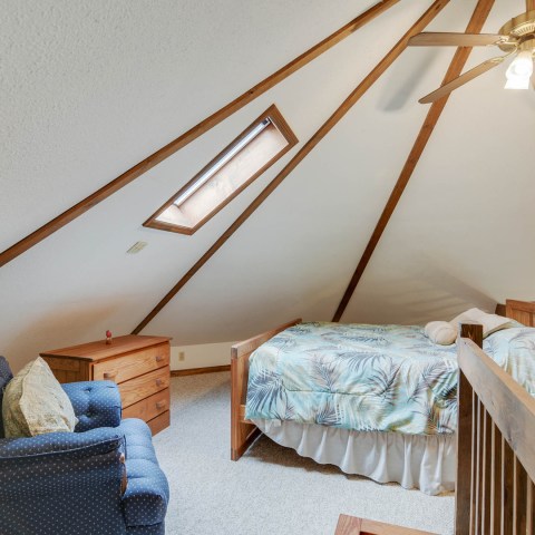 a bedroom with a bed and a chair in a room