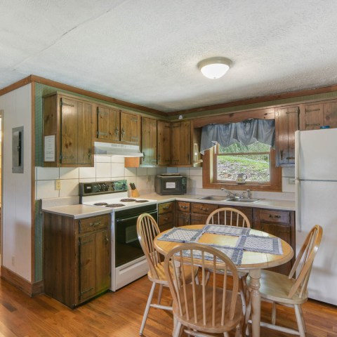 a kitchen with wooden cabinets and a dining room table