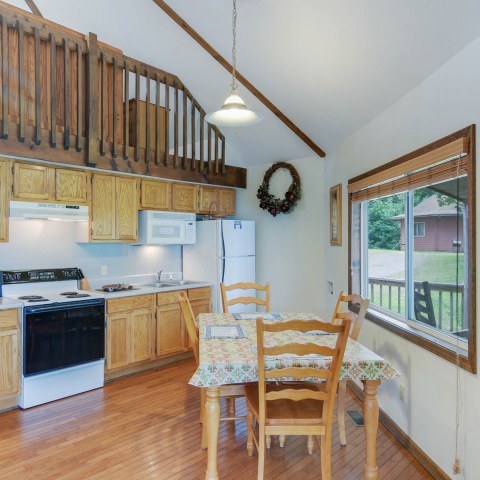 a kitchen with wooden cabinets and a dining room table