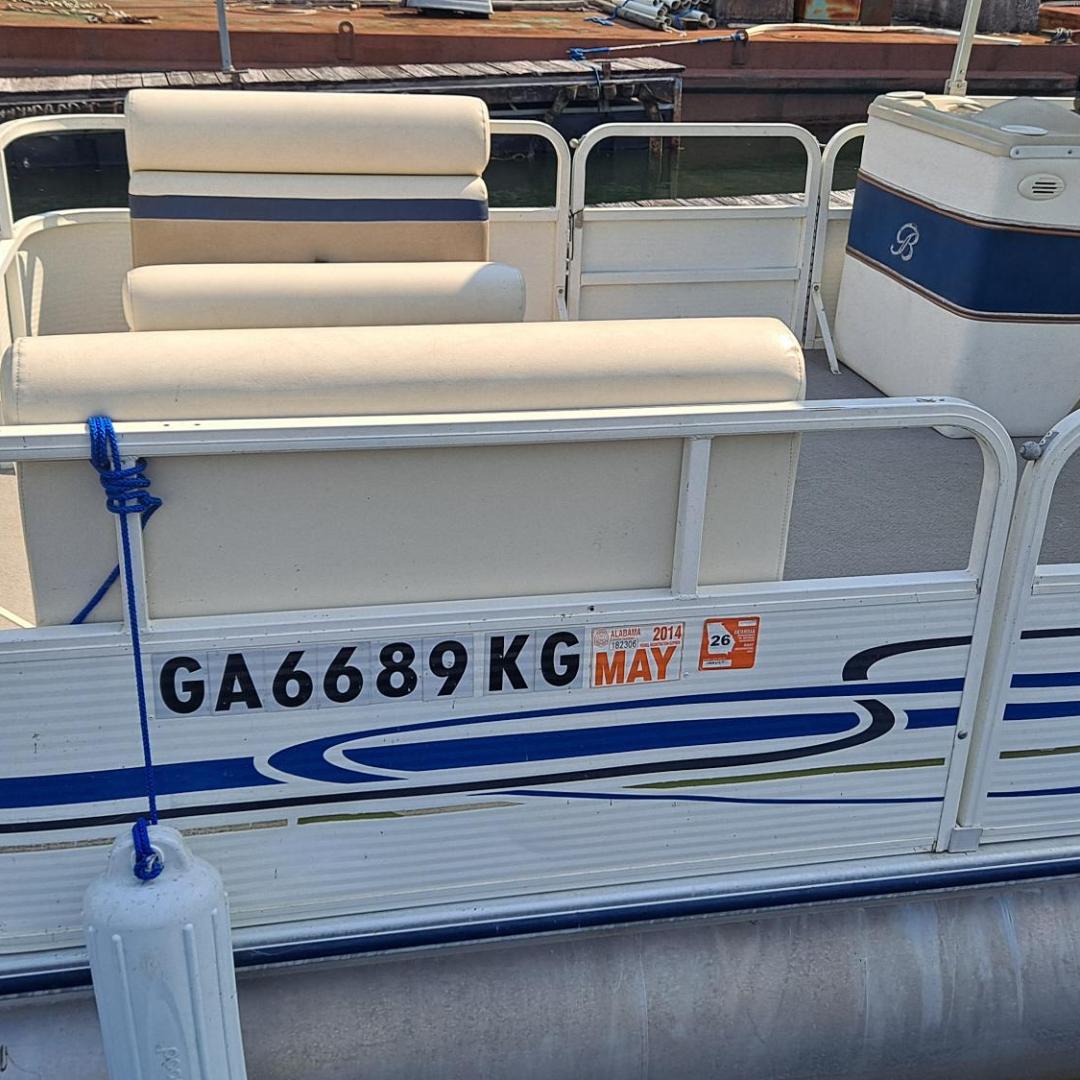 Pontoon boat with blue accents at dock, registration number GA6689KG visible on side.