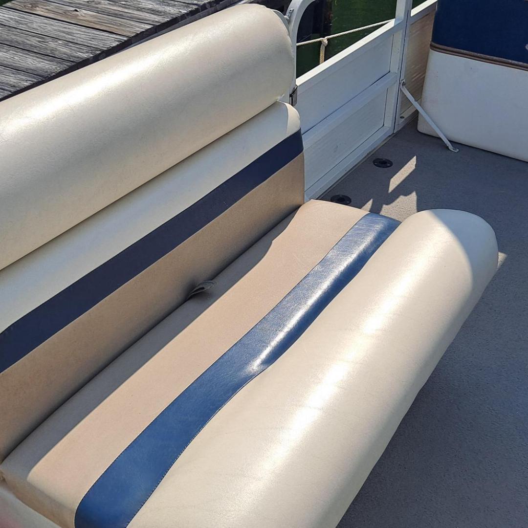 Cream and blue boat seat with backrest, partially shaded deck in background.