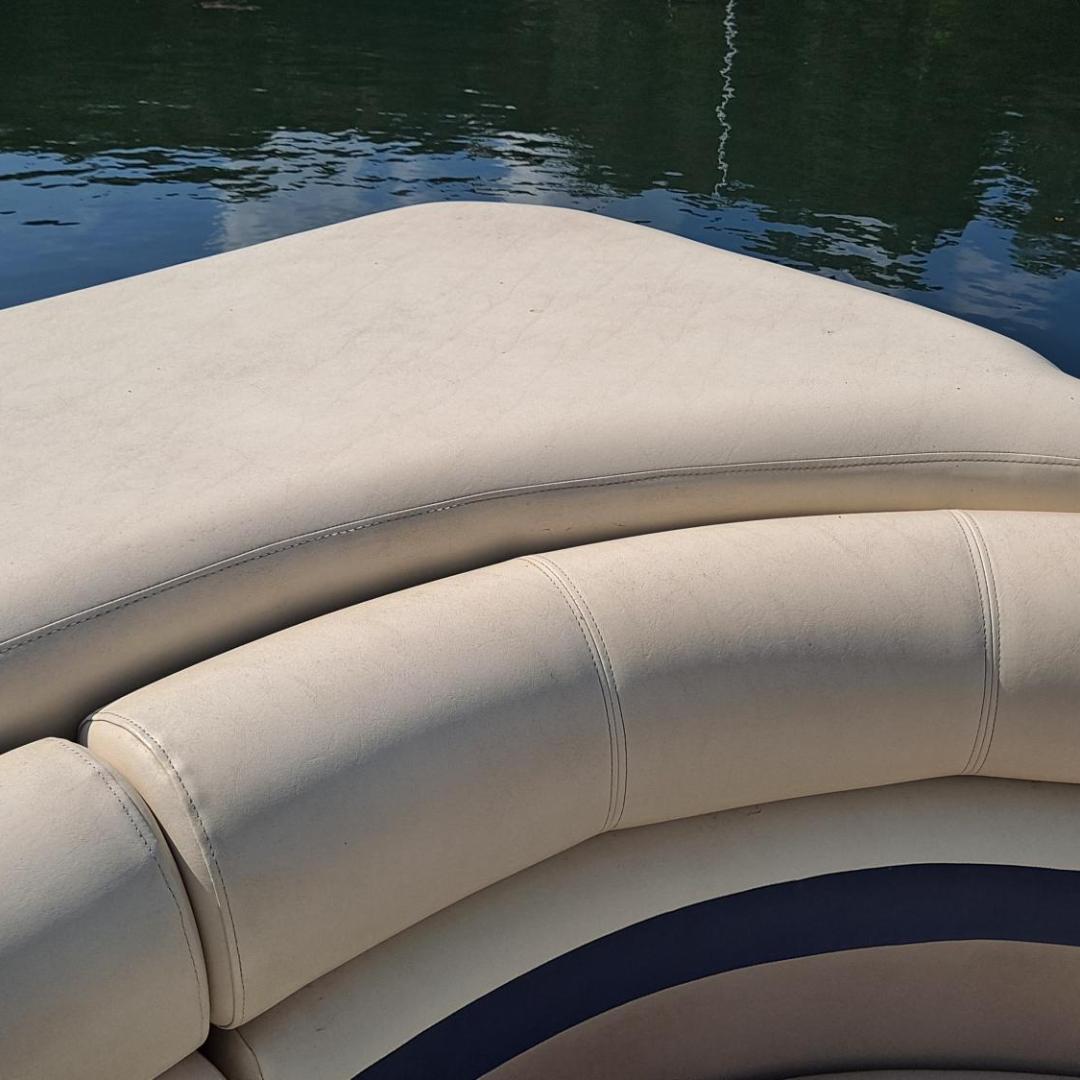 Beige boat cushions with water and dock in the background.