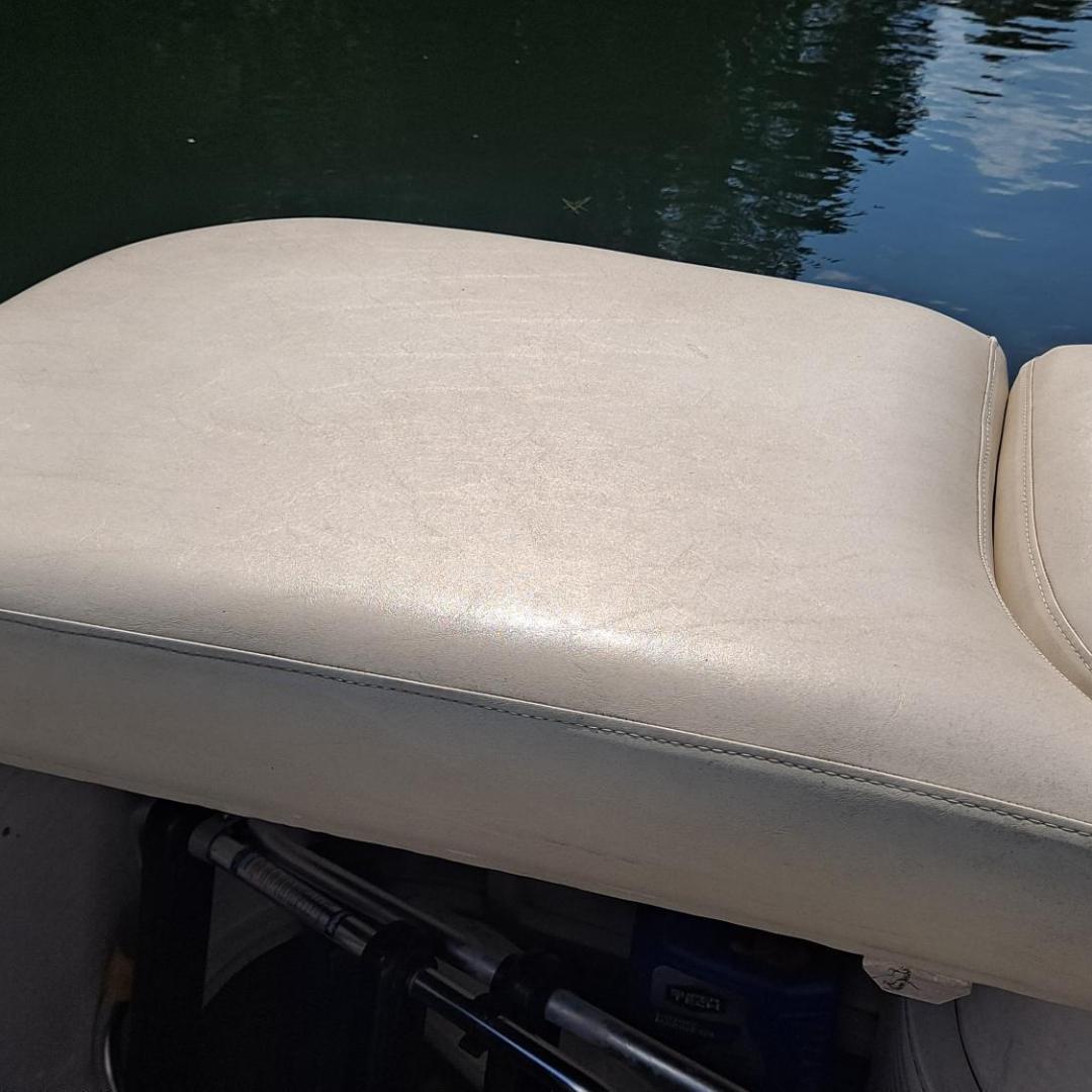 Tan boat seat with water reflection in the background.