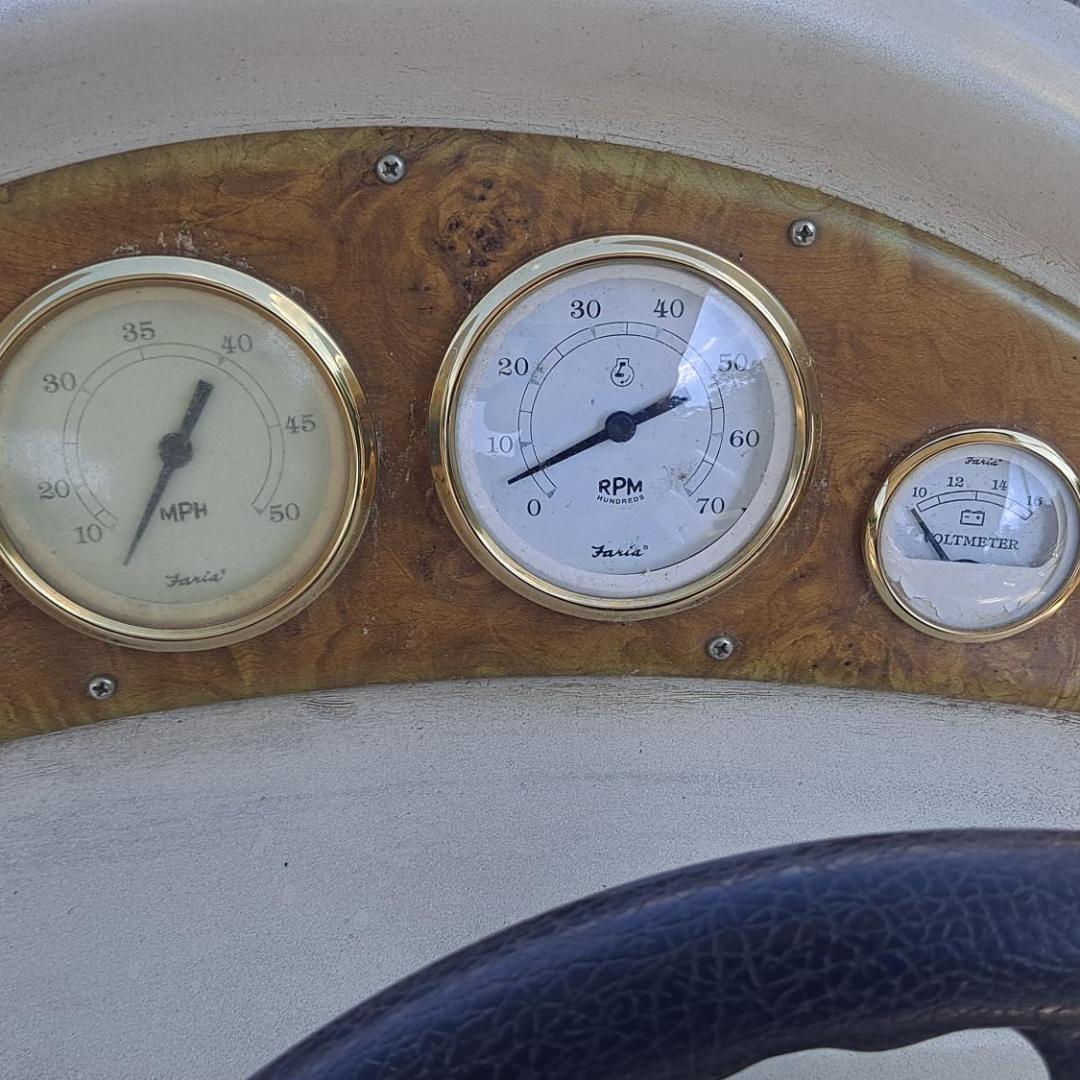 Boat dashboard with gauges for speed (MPH), RPM, fuel level, and voltmeter.