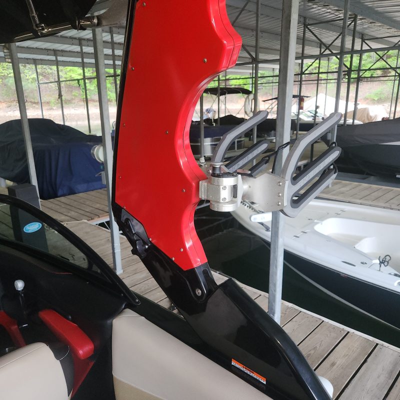 Red and black boat equipment with metal frame on a dock.