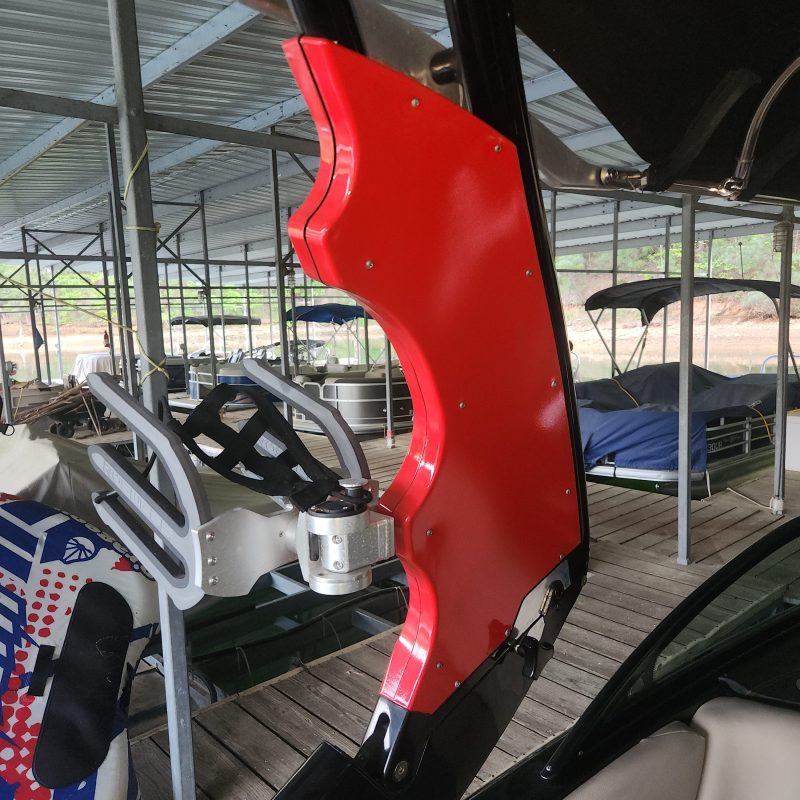 Red panel on a boat with a metal rack, under a covered dock area.