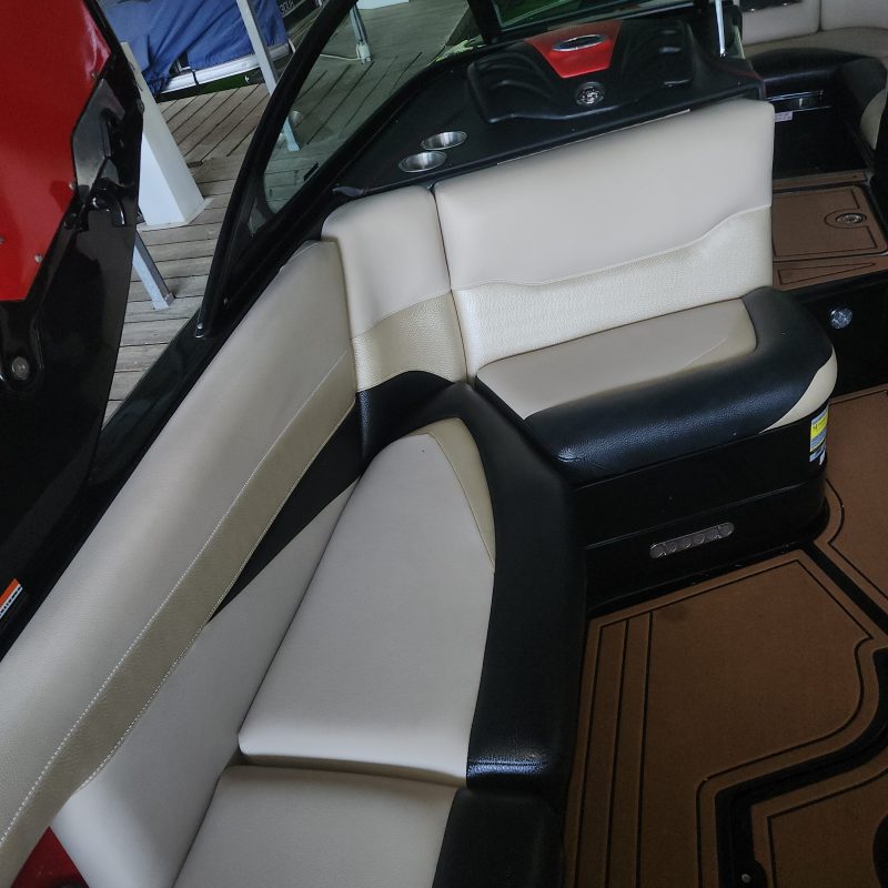 Interior of a boat with white and black cushioned seating.