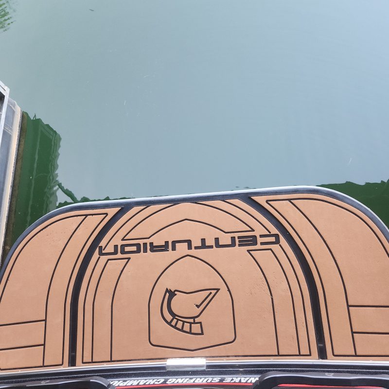 Boat stern with Centurion logo reflected in the water.
