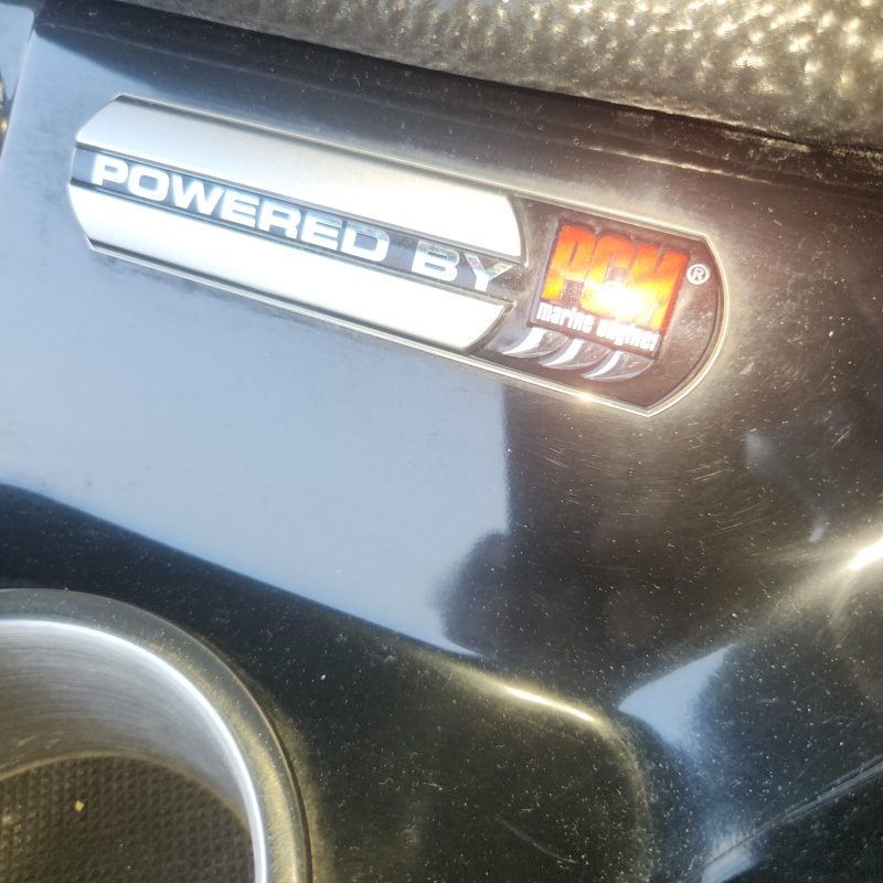 Close-up of a 'Powered by NOS' badge on a car dashboard.
