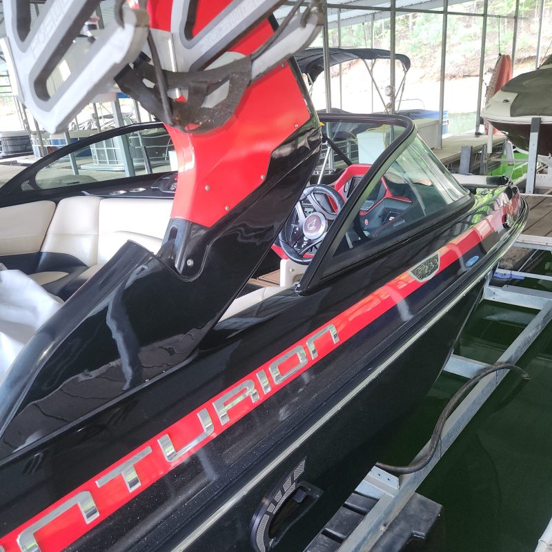 Interior of a parked motorboat with red accents and steering wheel visible.