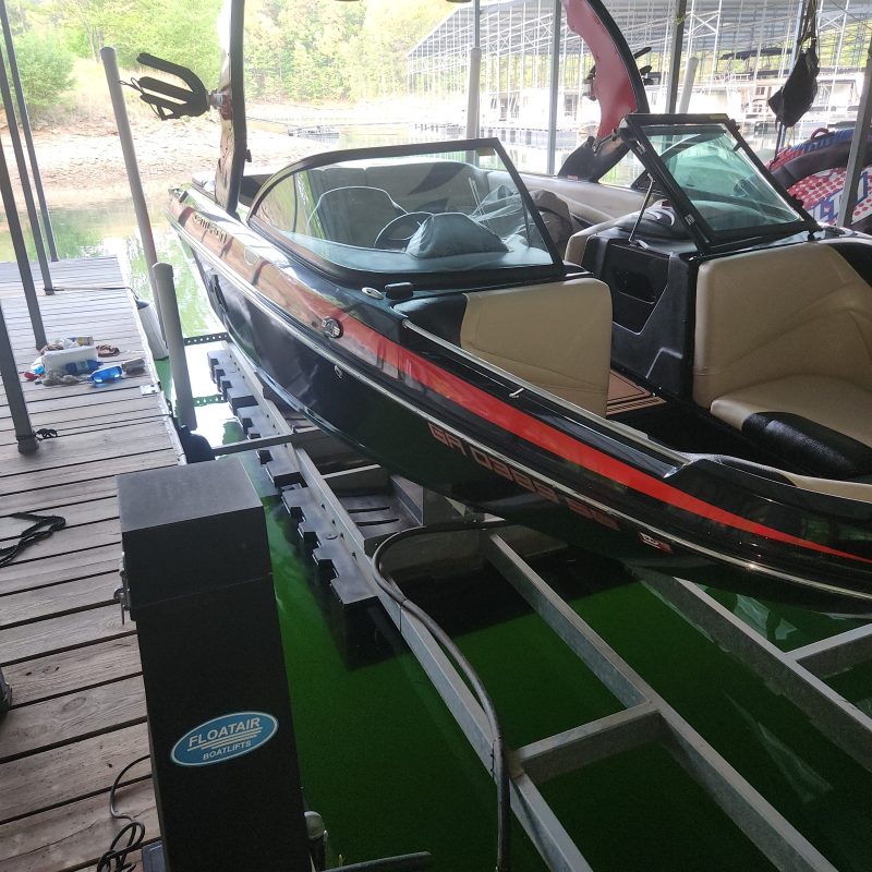 Speedboat docked in a covered marina on a sunny day.