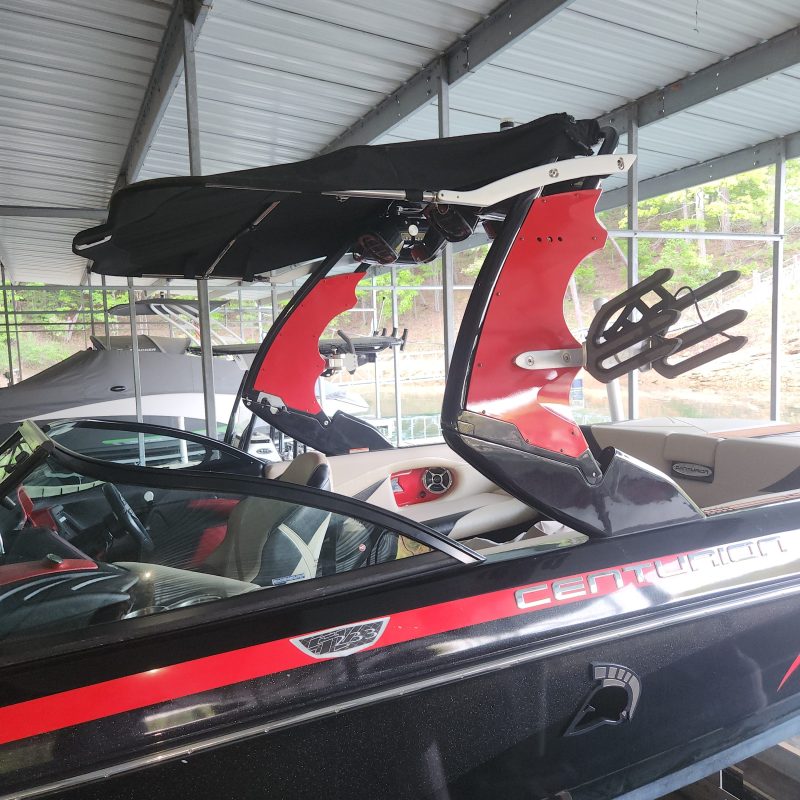 Red and black wakeboard boat seats stored vertically in a shed.