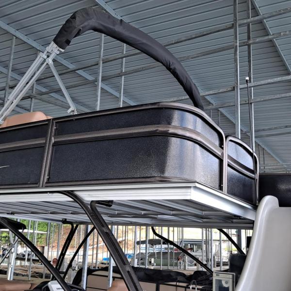 Two-level boat docked under a metal roof.