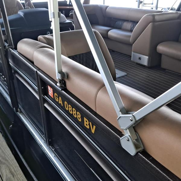 Pontoon boat with brown seating docked at a marina.