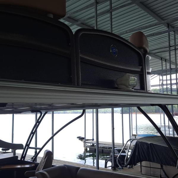 Close-up of a boat docked in a covered marina with other boats nearby.