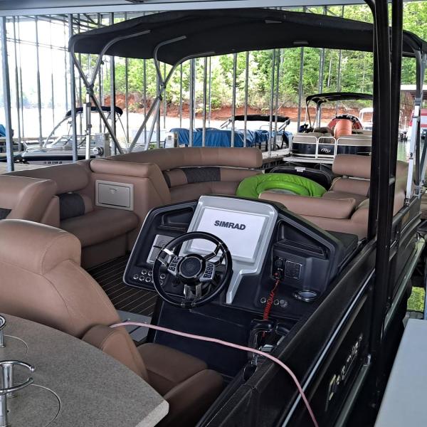 Interior of a docked pontoon boat under a covered marina