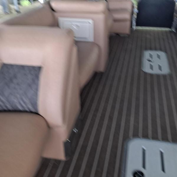 Blurry photo of a boat's interior with brown seats and striped floor.