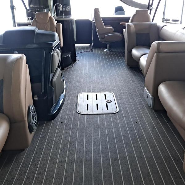 Luxury yacht interior with brown leather seating and striped carpet.