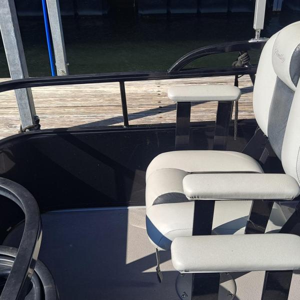 Fishing boat seat facing a dock with metal rails around.