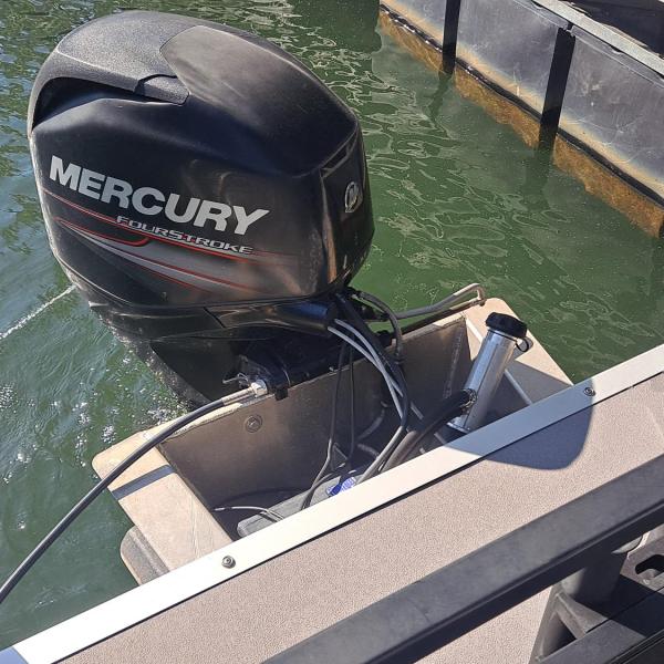 Boat with Mercury outboard motor docked at pier.