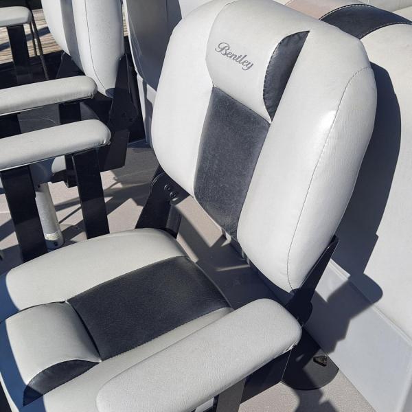 Grey and black boat seats with armrests on a sunny day.