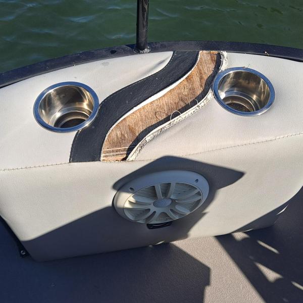 Boat seat with cup holders and speaker on sunny day.