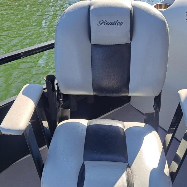 Boat seat with armrests, labeled 'Bentley,' on a green water background.
