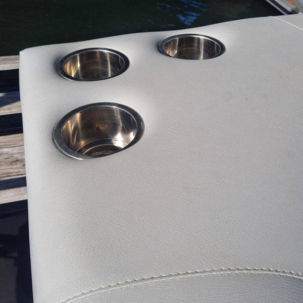 Close-up of boat seat with three cup holders on a sunny day.
