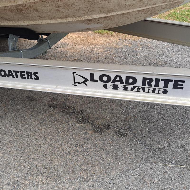 Trailer with text 'Happy Boaters Load Rite' on the side, parked on pavement.